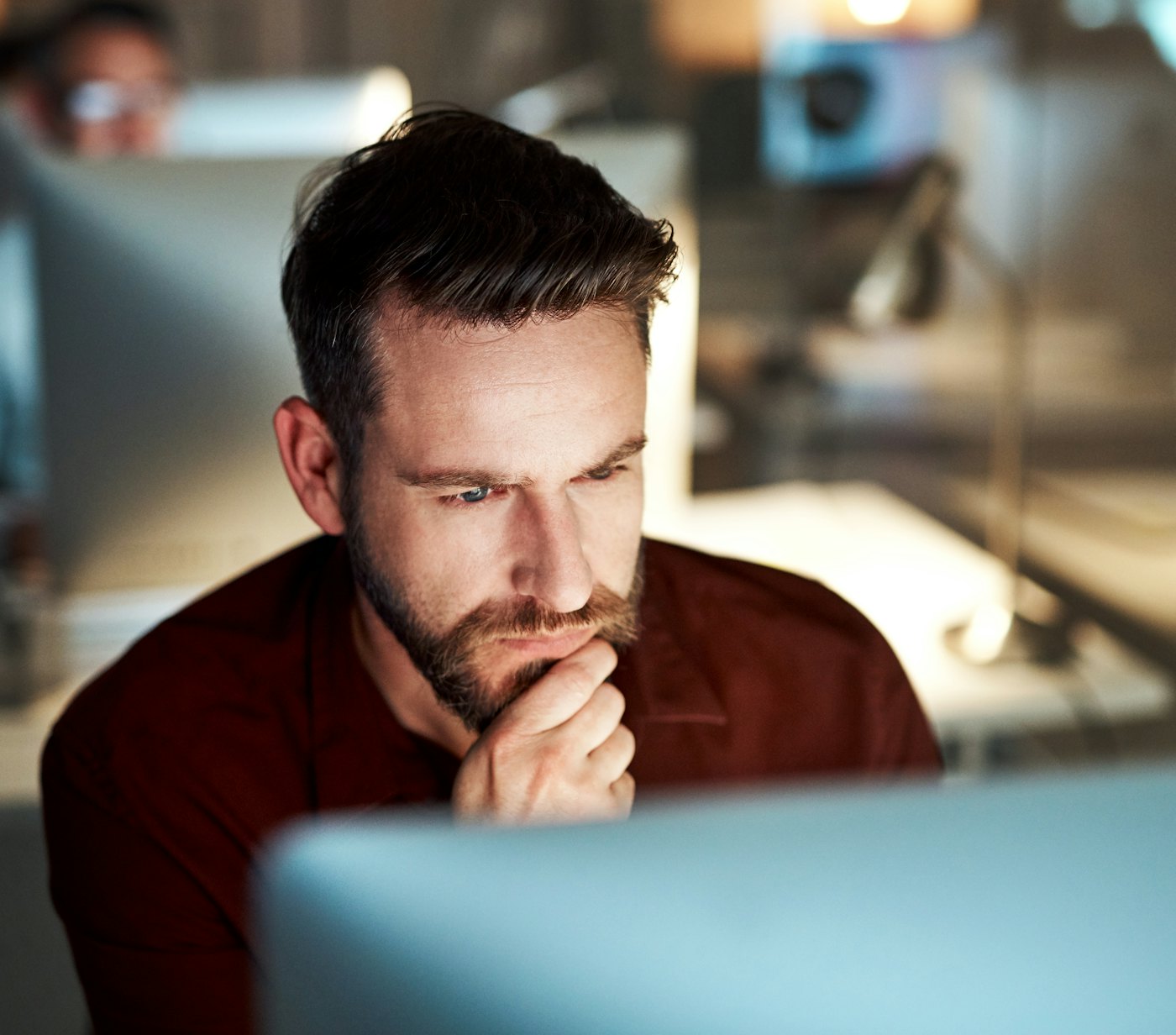 Man sitting behind screen thinking