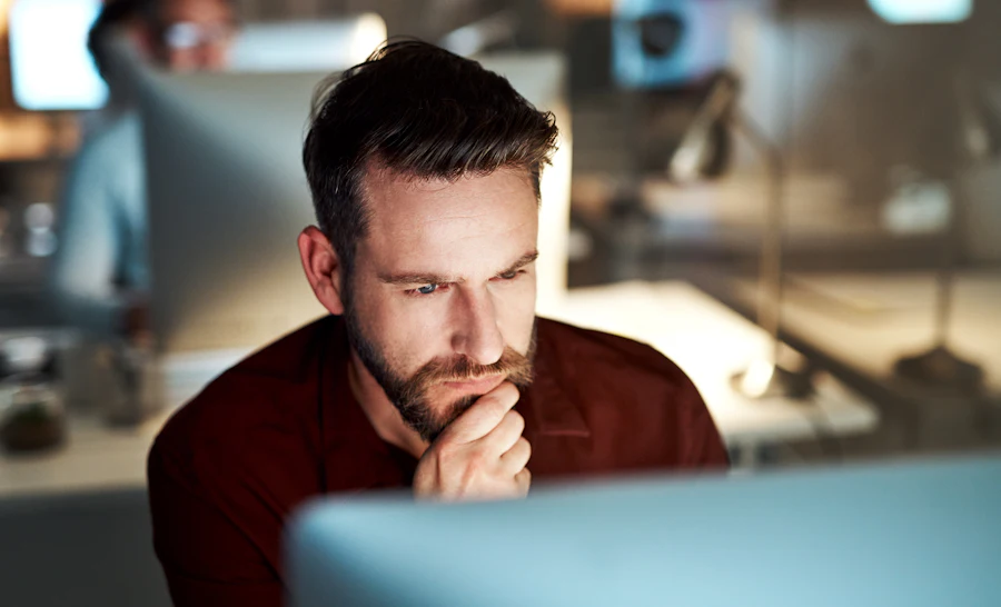 Man sitting behind screen reading about cybersecurity in 2026