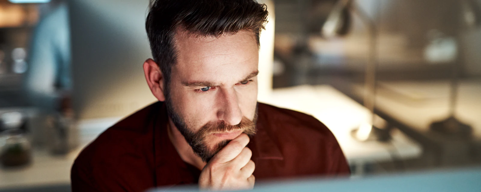 Man sitting behind screen reading about cybersecurity in 2026