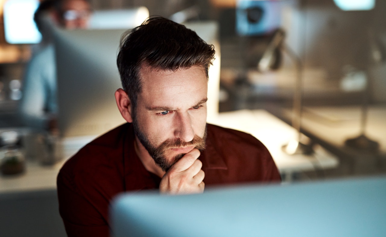 Man sitting behind screen thinking