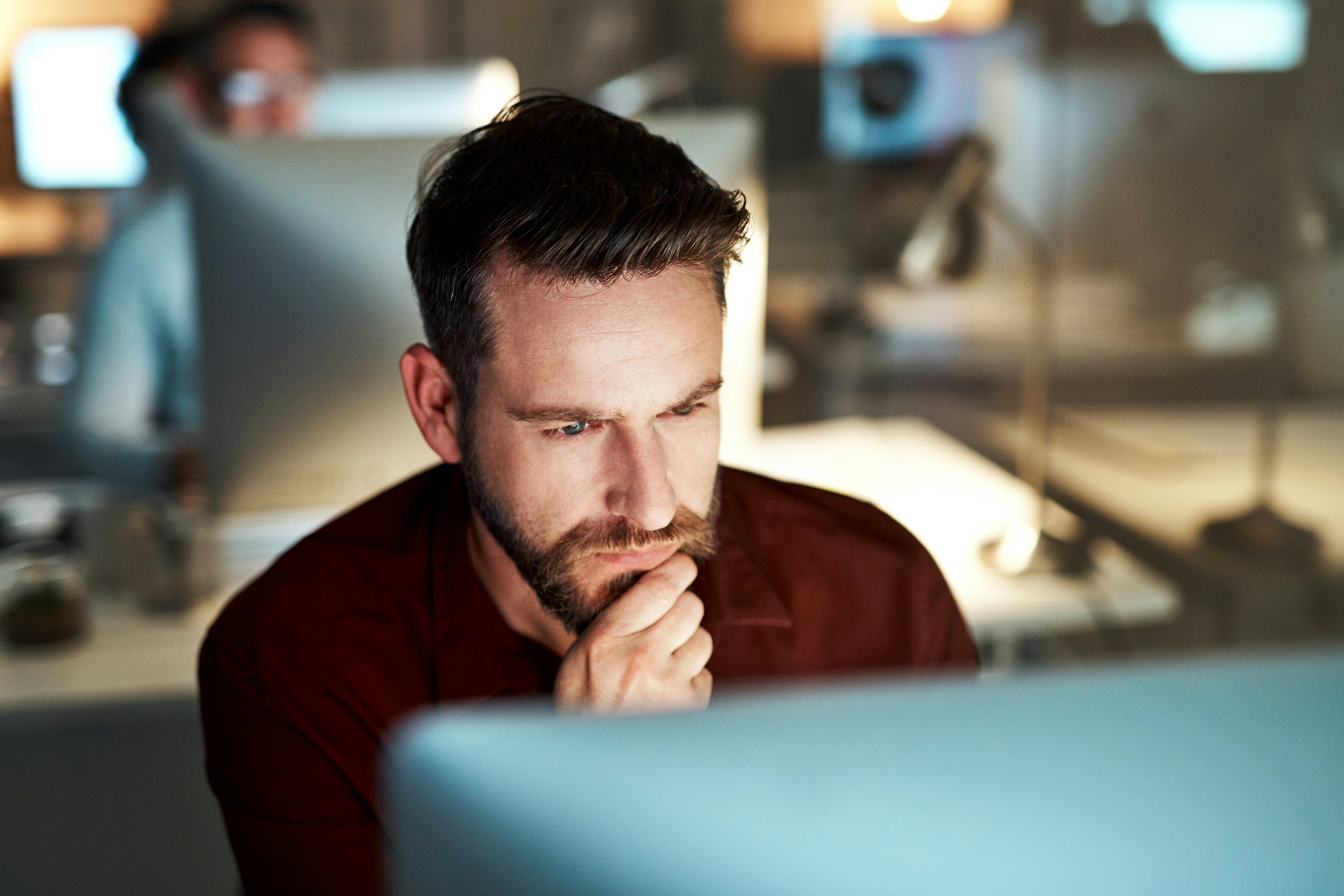 Man sitting behind screen thinking