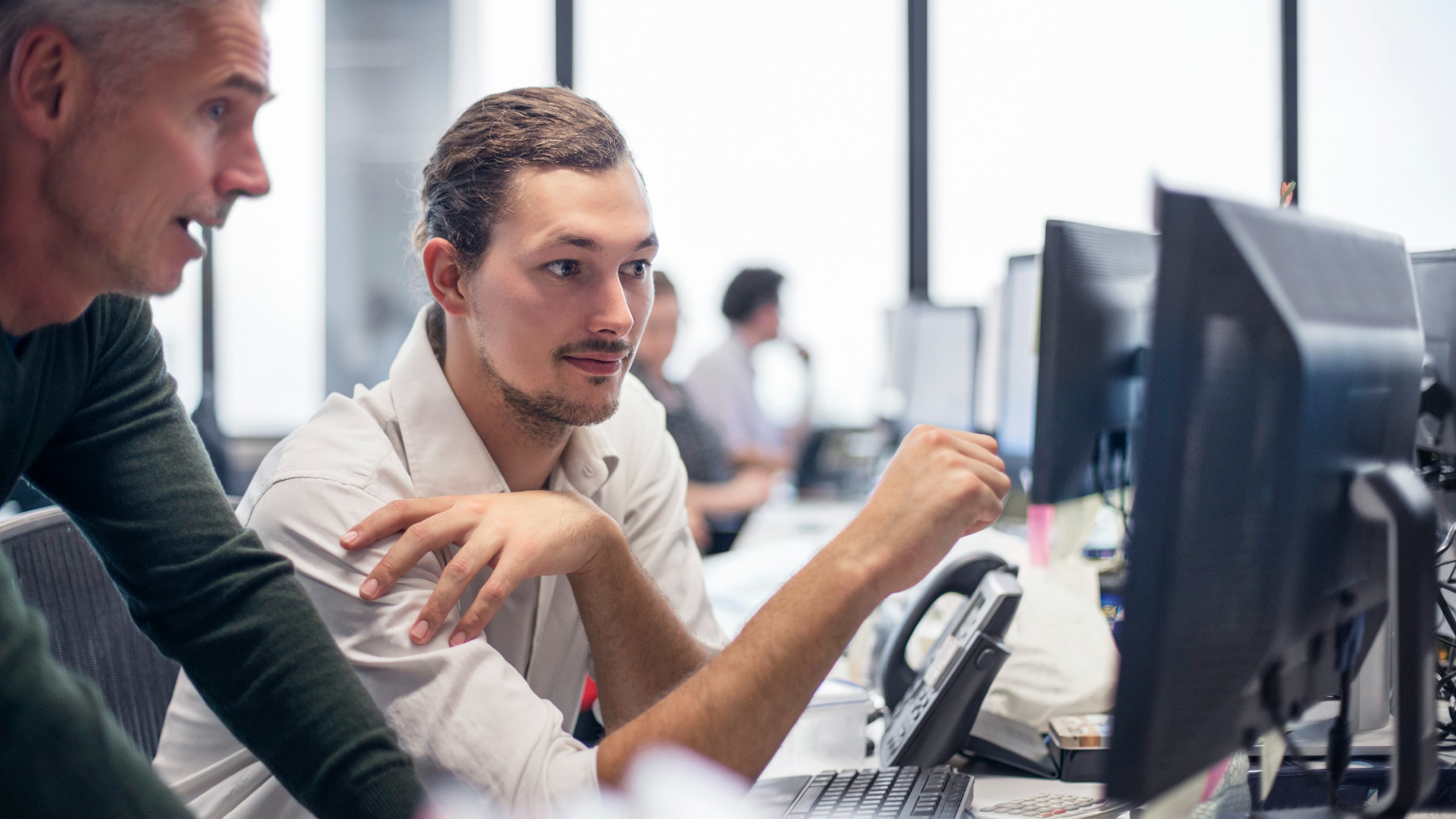 2 persons behind a screen