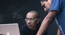 Two men looking at a laptop