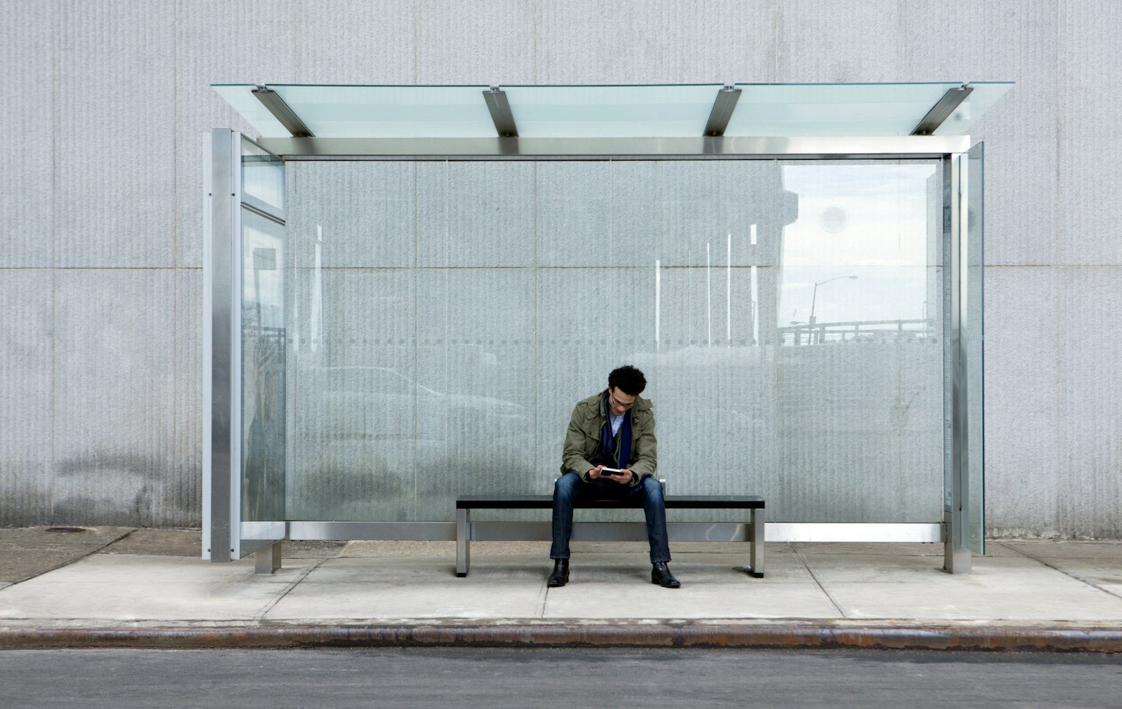 Man using smartphone bus stop