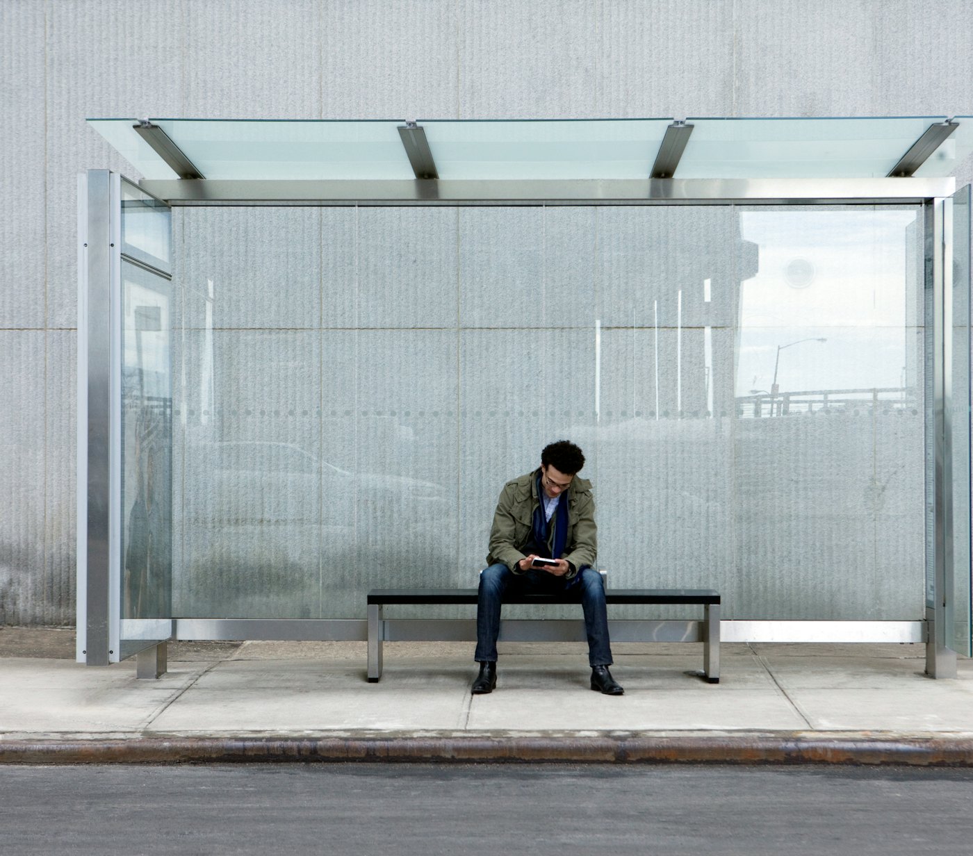 Man using smartphone bus stop