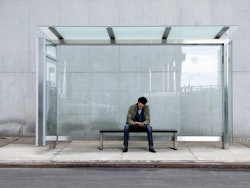 Man using smartphone bus stop