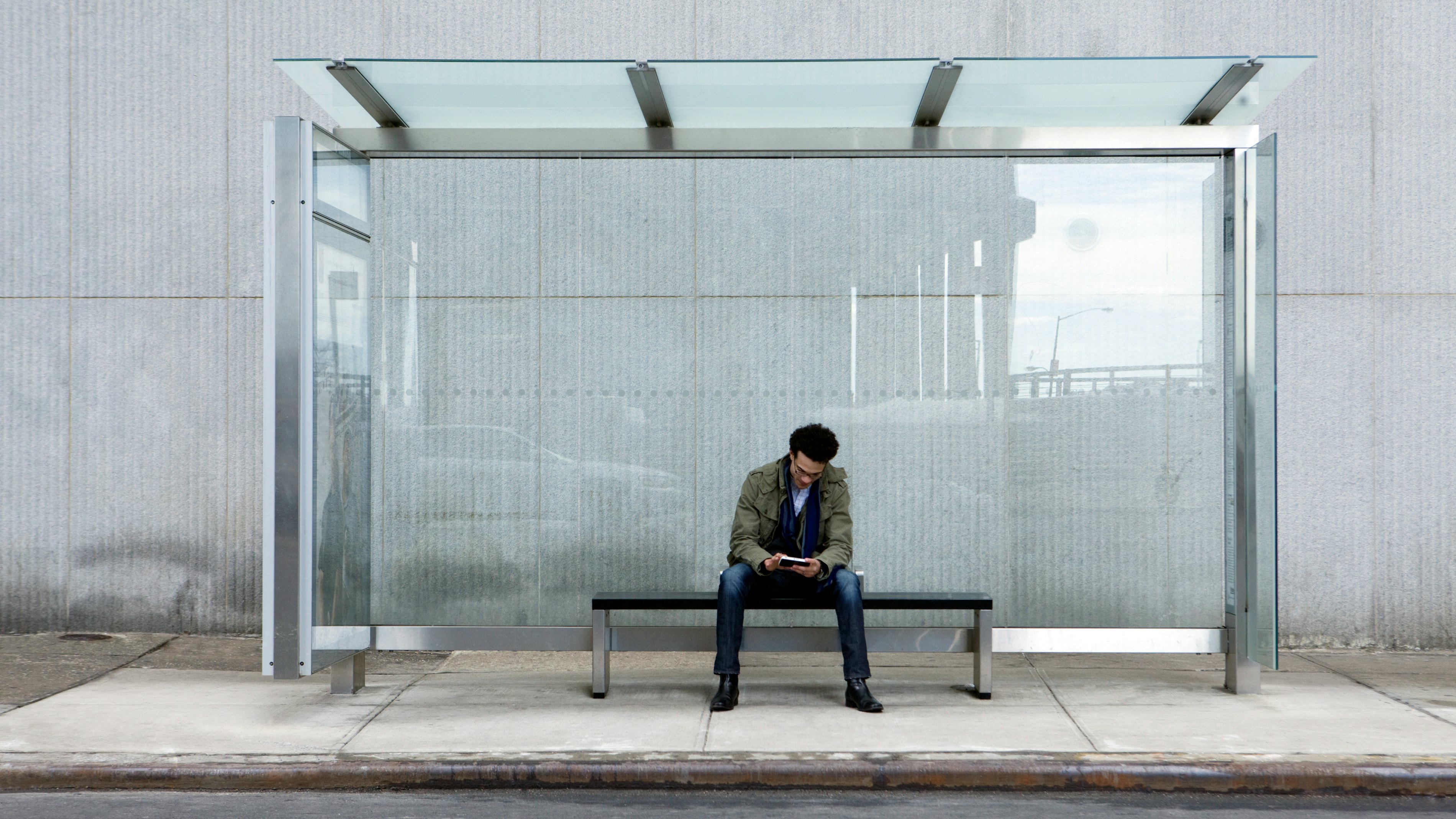 Man using smartphone bus stop