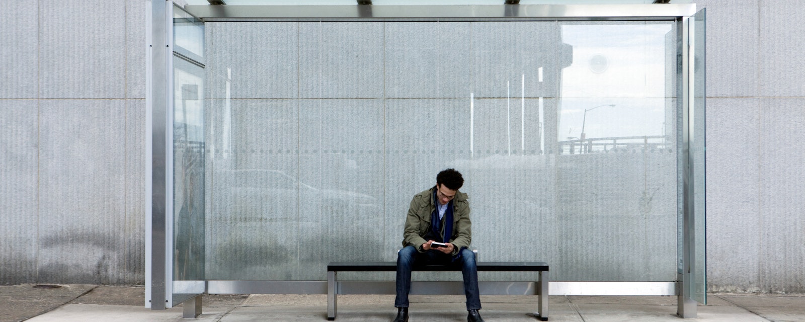Man using smartphone bus stop