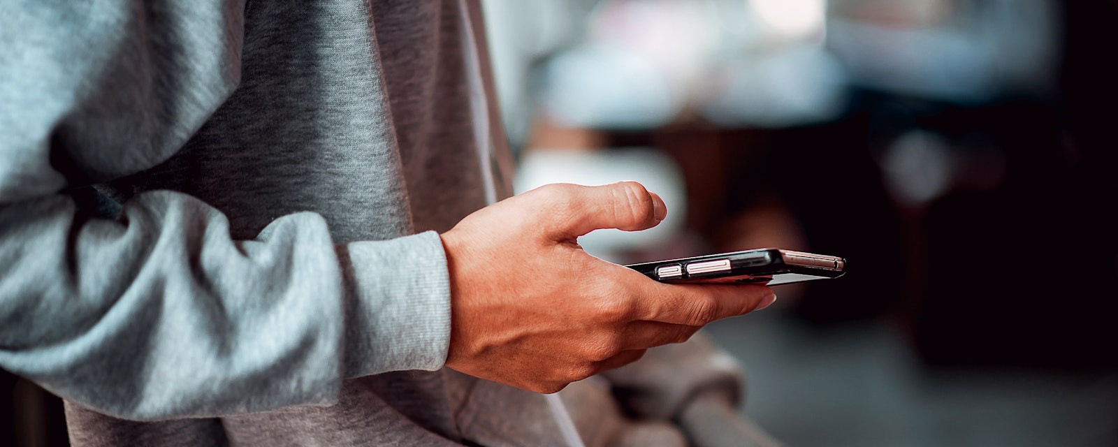 Closeup young man holding smartphone