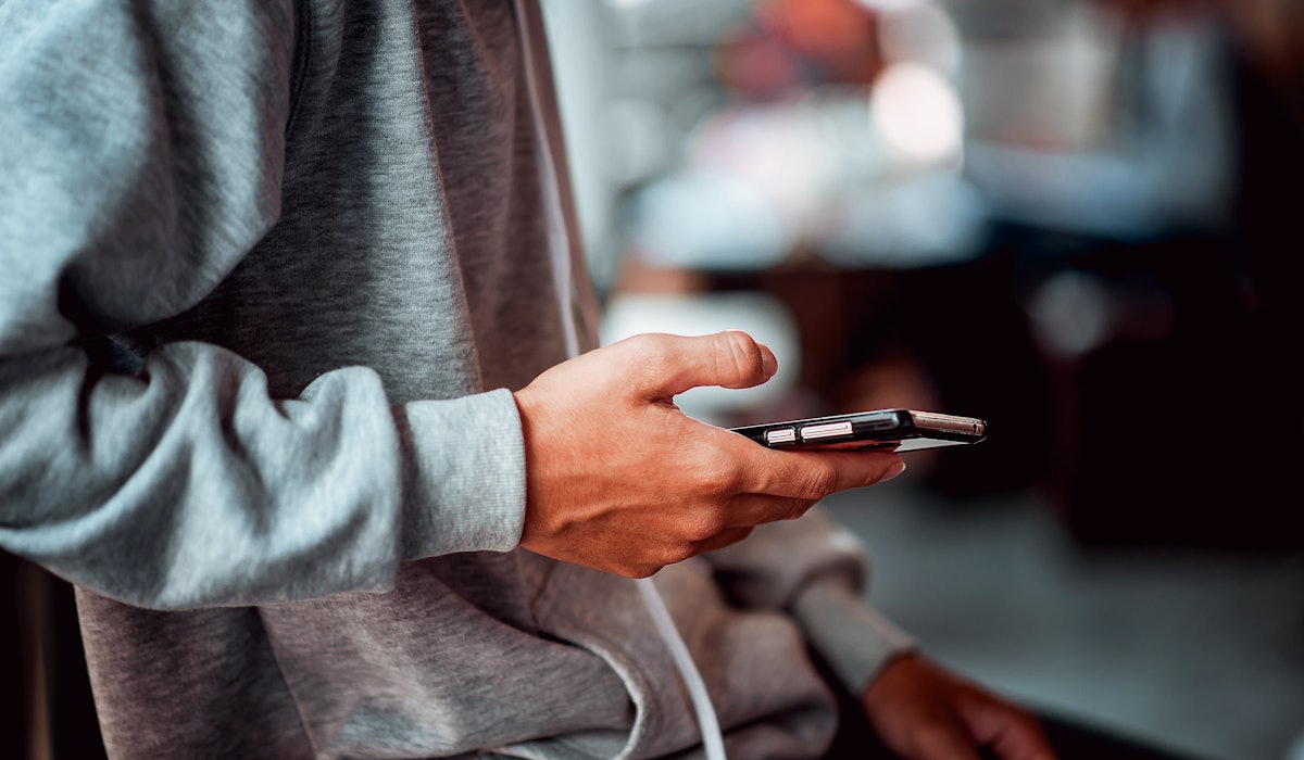 Closeup young man holding smartphone