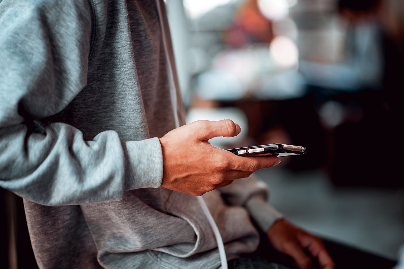 Closeup young man holding smartphone
