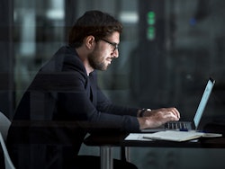 Man sitting behind laptop quantum computing threat