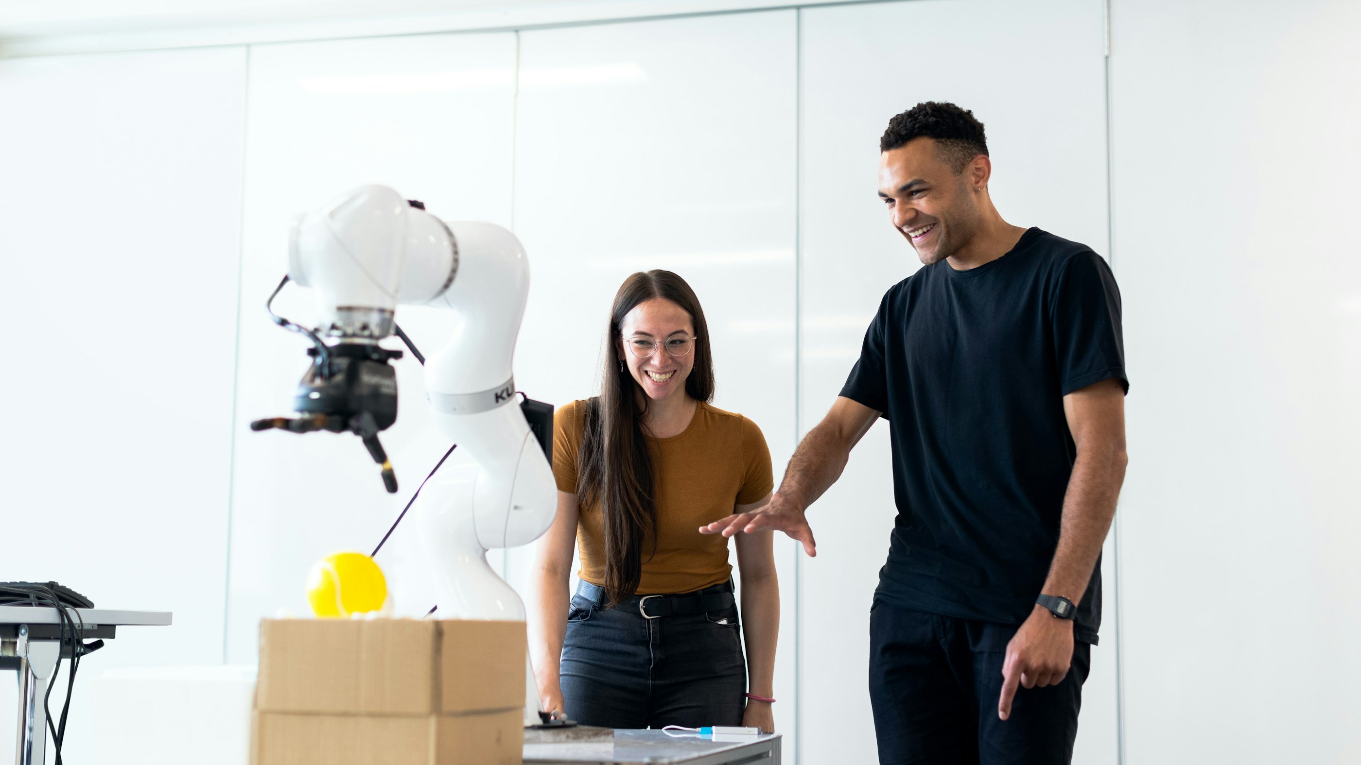 Man and girl testing robotic arm laughing