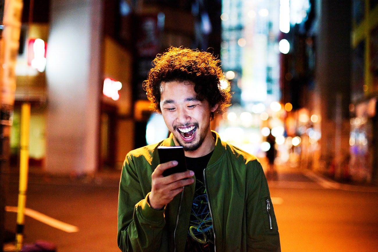 Japanese man laughing with phone