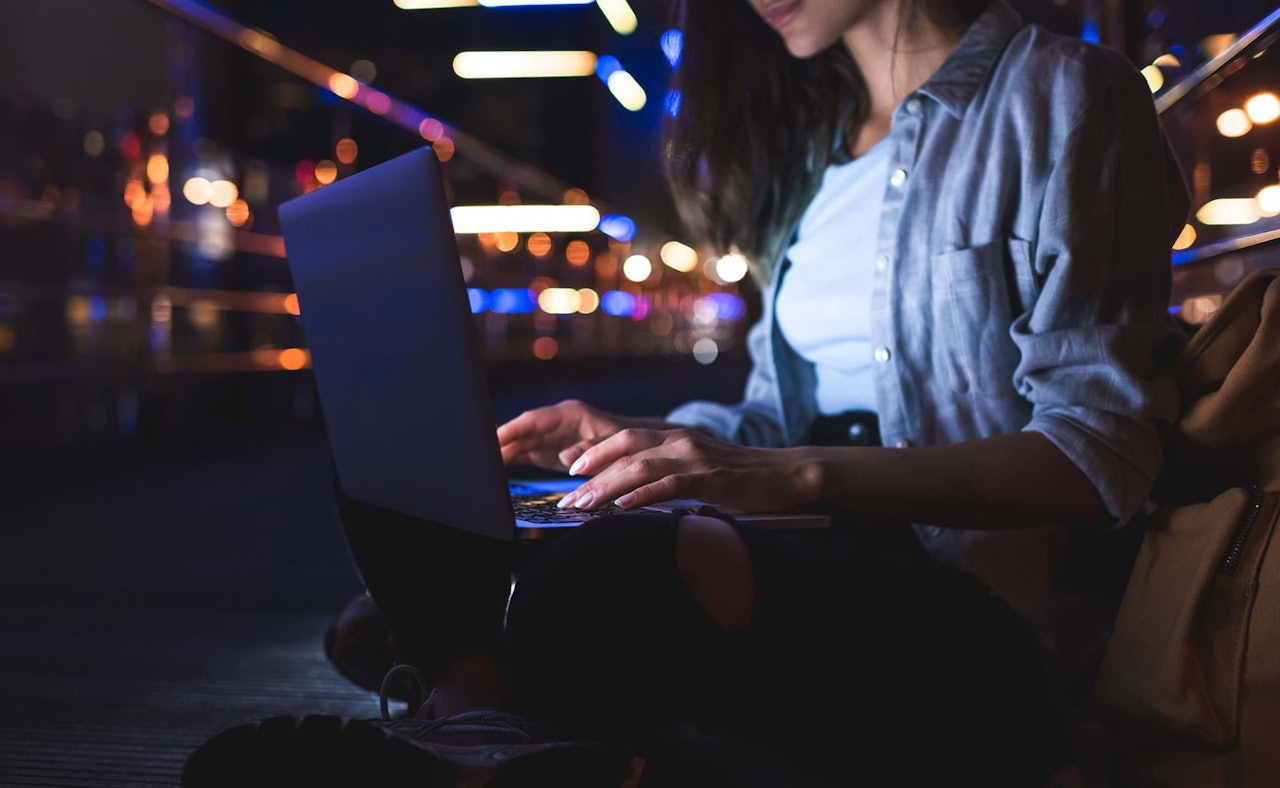 Partial view of woman using laptop